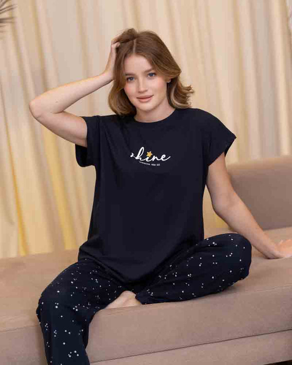 تي شيرت كحلي نص كم بطبعة Shine مع بنطلون طويل كحلي بنقشة صغيرة متفرقة في وضع الجلوس